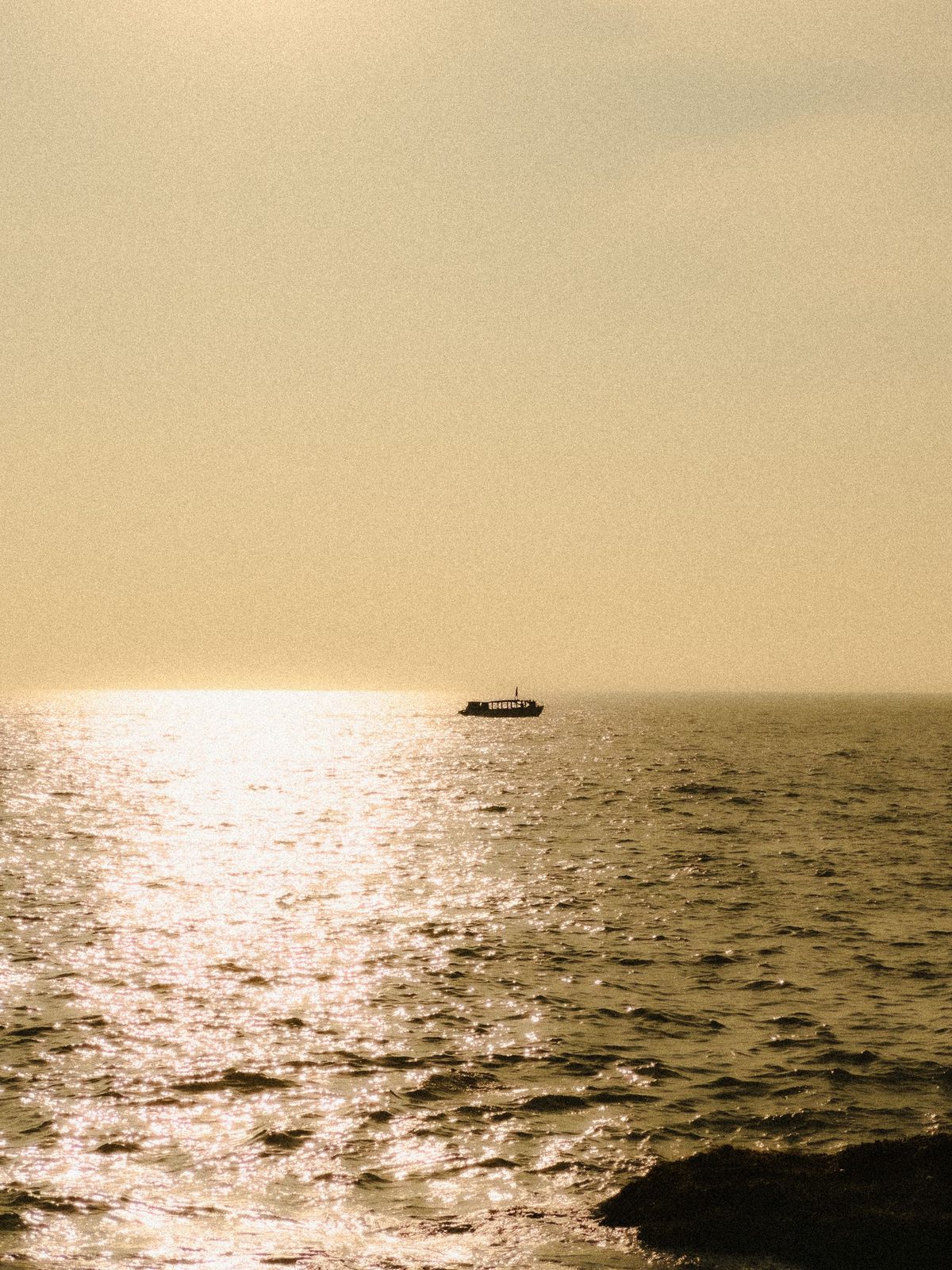 Boat on the shining sea at sunset, Gokarna